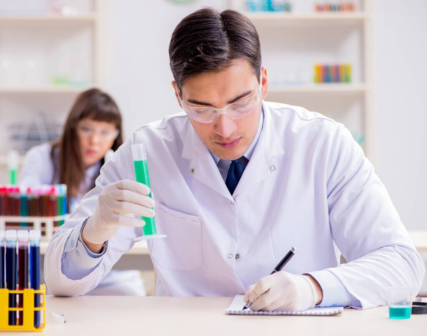 Two chemists working in lab experimenting - Foto, Imagen