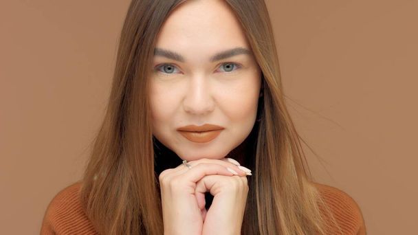 Monochrome brown look caucasian womancloseup on brown background - Fotó, kép