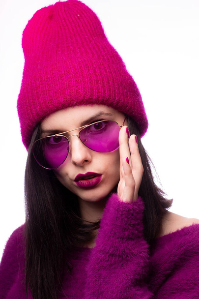 girl in a purple sweater, purple glasses with purple lipstick on the lips in a pink hat - Foto, Bild