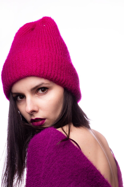 girl in a purple sweater with purple lipstick on the lips in a pink hat - Фото, изображение