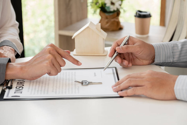 pośrednik w obrocie nieruchomościami z domowymi formularzami ubezpieczeniowymi Aby klient mógł podpisać umowę zgodnie z umową oficjalnie wykupić ubezpieczenie domu. - Zdjęcie, obraz