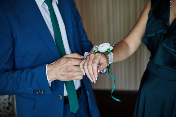 Groom corrige Bride boutonnière à portée de main lors de leur mariage détails de gros plan
 - Photo, image