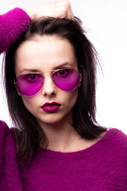 girl in a purple sweater, purple glasses with purple lipstick on her lips - 写真・画像