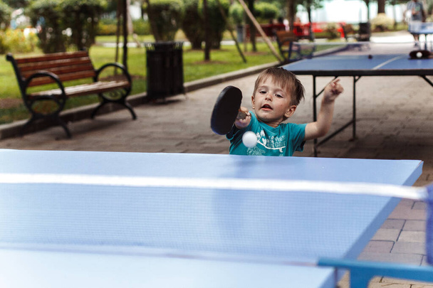 Little boy playing table tennis - Fotó, kép