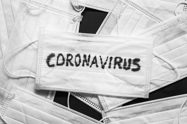 Concept of a coronavirus pandemic.Medical Disposable Face Mask with covid-19 printed on it. Covid-19 - Wuhan Novel Coronavirus pneumonia gets official name from WHO: COVID-19. Disposable breath filter face mask with earloop. - Fotó, kép