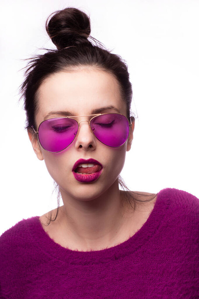 girl in a purple sweater, purple glasses with purple lipstick on her lips - Foto, imagen