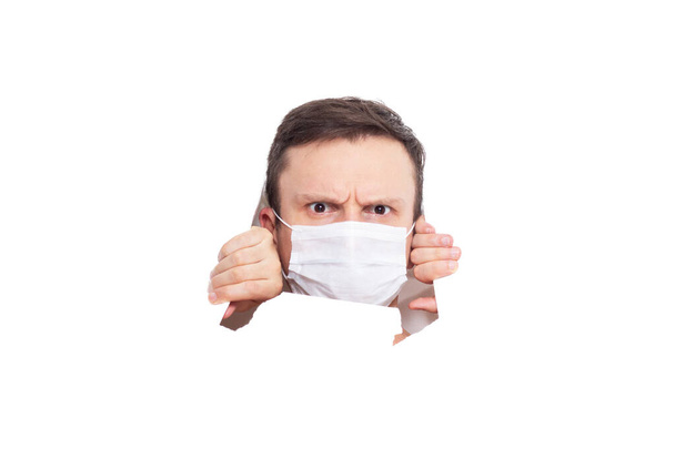 Portrait of a man on a white isolated background, face covered with a medical mask, banner for text. Health, awareness, and timeliness. Healthy lifestyle. No viruses. Fear of getting sick - Zdjęcie, obraz