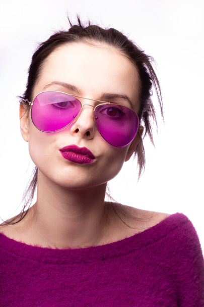 girl in a purple sweater, purple glasses with purple lipstick on her lips - Fotó, kép