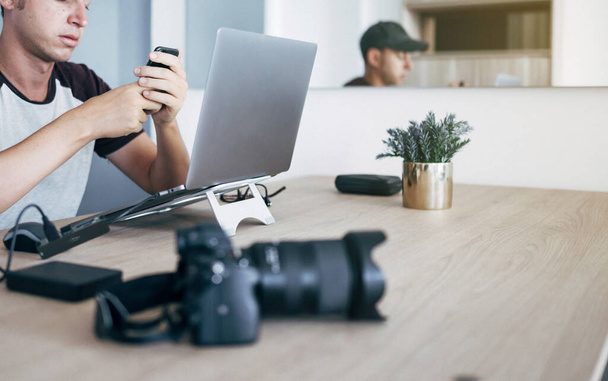インターネットをサーフィンする机の上に座っているラップトップコンピュータ上で自宅から働く男 - 写真・画像