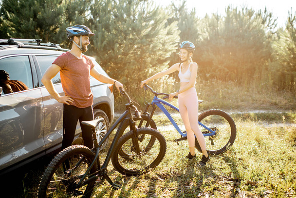 Jovem casal com bicicletas perto do carro ao ar livre
 - Foto, Imagem
