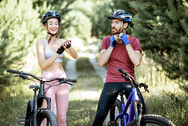 Homme et femme se préparant pour la bicyclette à l'extérieur
 - Photo, image