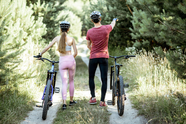 Młoda para spacerująca z rowerami na świeżym powietrzu - Zdjęcie, obraz