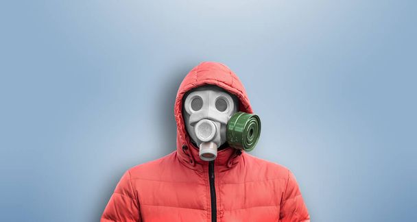 man in gas mask and a hood on a blue background - Valokuva, kuva