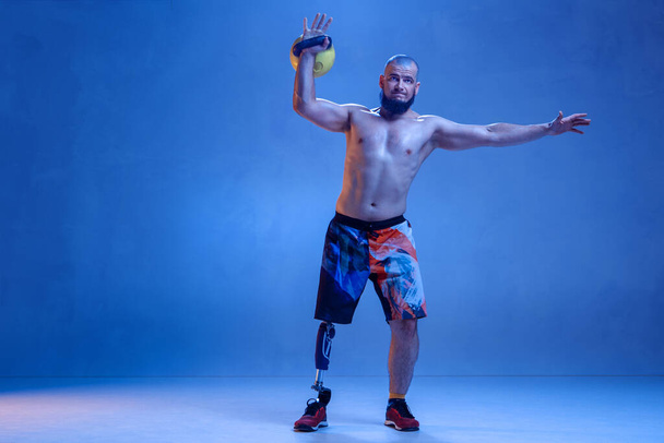 Athlete disabled amputee isolated on blue studio background - Fotoğraf, Görsel