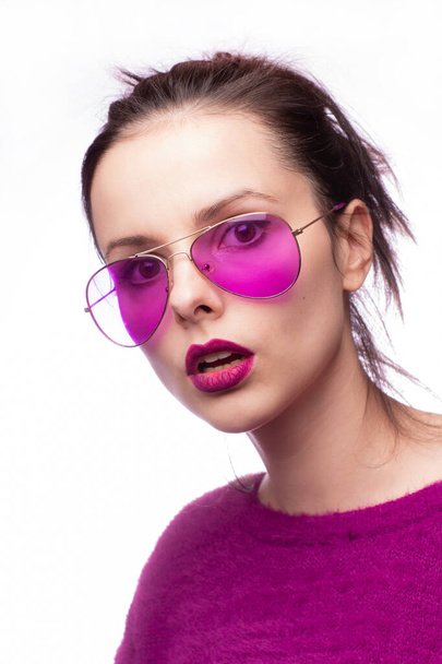 girl in a purple sweater, purple glasses with purple lipstick on her lips - Fotografie, Obrázek
