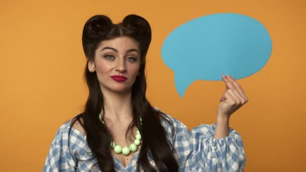 Smiling pin up girl shaking head and pointing with finger at speech bubble - Metraje, vídeo