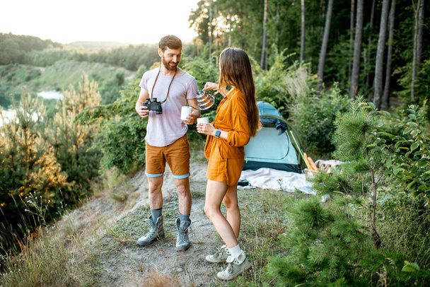 森の中でキャンプをしている若いカップル - 写真・画像