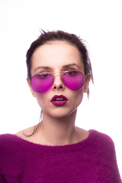 girl in a purple sweater, purple glasses with purple lipstick on her lips - Fotografie, Obrázek