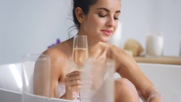 Sexy woman taking bath with glass of wine. Nude girl relaxing with champagne - Filmati, video