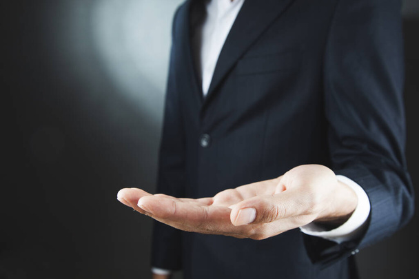businessman open hand on dark background - Фото, изображение