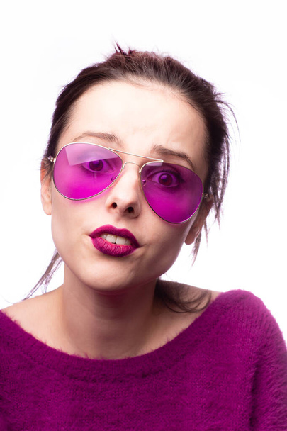 girl in a purple sweater, purple glasses with purple lipstick on her lips - Foto, Imagem