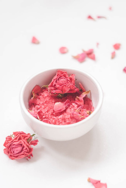 White bowl with sea salt with extract and smell of roses, dried rose buds on a light background - Fotografie, Obrázek