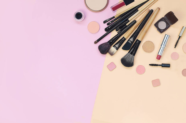 Colorful cosmetics lying on pink and yellow background. Flatlay - Fotó, kép