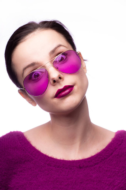 girl in a purple sweater, purple glasses with purple lipstick on her lips - Foto, Imagen
