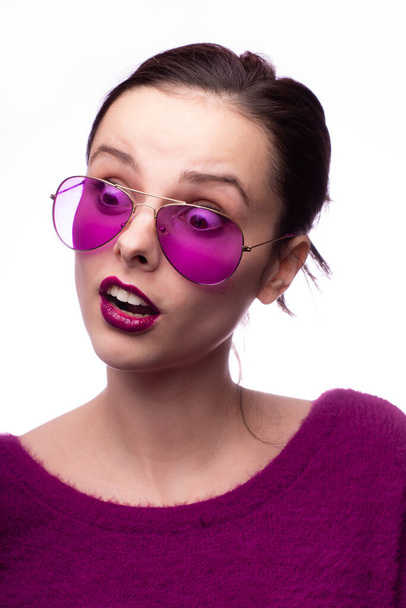 girl in a purple sweater, purple glasses with purple lipstick on her lips - Фото, зображення