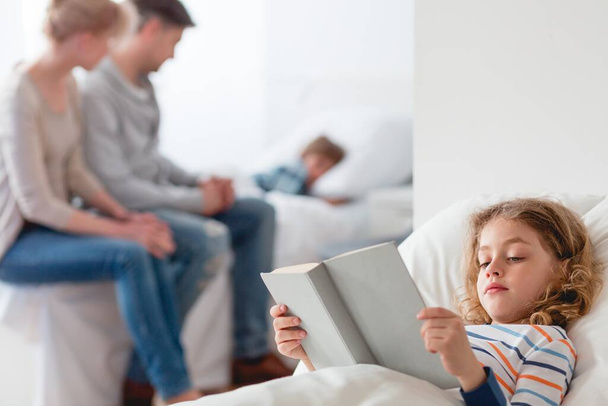 Bambina in ospedale a leggere un libro prima di dormire
 - Foto, immagini
