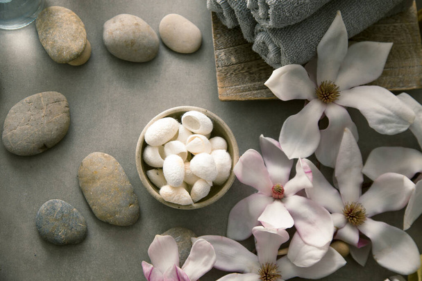 Spa and wellness. Natural massage stones , silkworm cocoon with magnolia flower .Spa treatment - Fotoğraf, Görsel