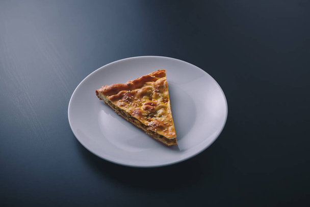 Κομμάτι κρέας και καρότο πίτα σε λευκό πιάτο σε μαύρο ξύλινο φόντο. Νόστιμο υγιεινό φαγητό. Διατροφή, διατροφή, διατροφικές συνήθειες. Θέση για κείμενο - Φωτογραφία, εικόνα