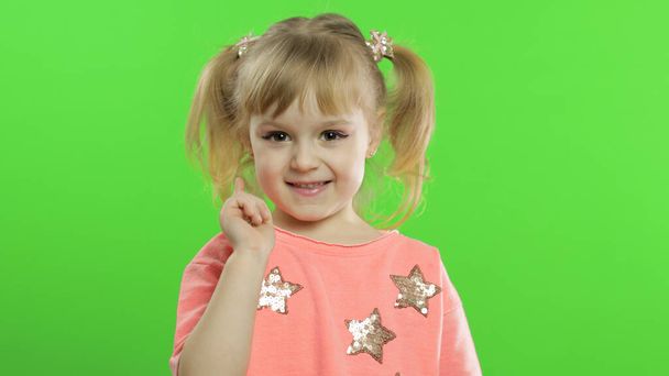 肯定的な幸せな女の子は星とピンクのブラウスで笑顔。クロマキー - 写真・画像