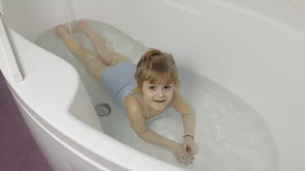 Schattig blond meisje neemt een bad in badmode. Klein kind, 4 jaar oud. Hygiëne - Video