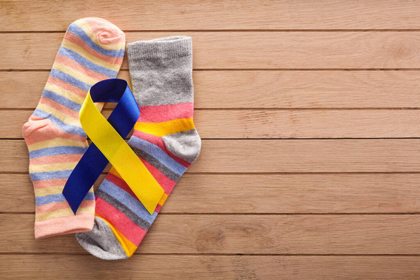 World Down syndrome day background. Down syndrome awareness concept. Socks and ribbon on wooden background - Foto, Bild