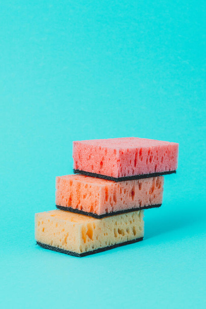 On a blue background, colored dishwashing sponges are arranged in steps.2020 - Фото, изображение