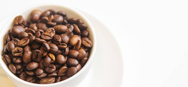 white cup and coffee beans on a white background. Selective focus. - Foto, immagini