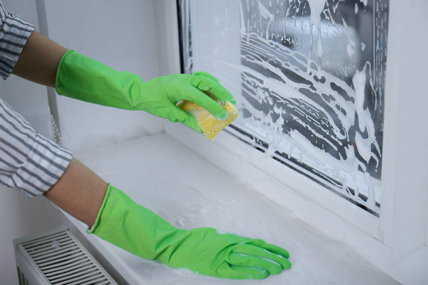 Γυναικείο παράθυρο καθαρισμού με σφουγγάρι σε εσωτερικούς χώρους, closeup - Φωτογραφία, εικόνα