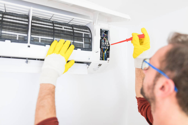 Klimatizace servis a údržba, upevnění AC jednotky a čištění filtrů. - Fotografie, Obrázek