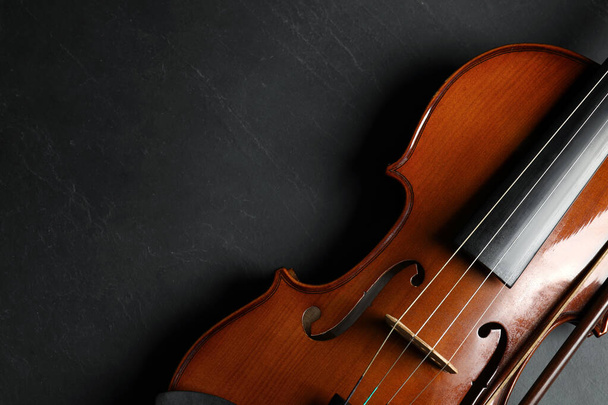 Classic violin and bow on black stone background, top view. Space for text - Fotografie, Obrázek