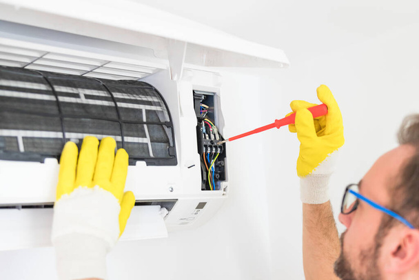 Aircondition service and maintenance, fixing AC unit and cleaning the filters. - Φωτογραφία, εικόνα