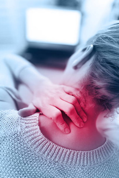 Woman working on a laptop and having neck pain / injury. - Photo, Image