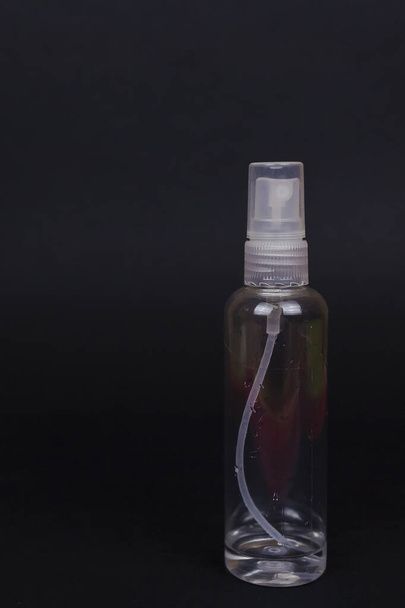 Transparent bottle with antiseptic residues. Crisis of household antiseptics in stores. Crisis due to coronavirus COVID-19 quarantine. Picture with black background and copy space - Photo, image