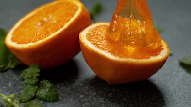 MACRO: Dulce mermelada casera se vierte sobre las mitades de naranja aromática
. - Metraje, vídeo
