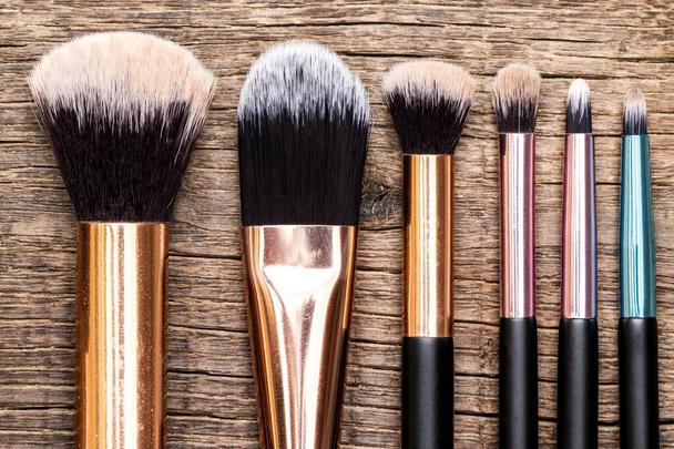 Set of makeup brushes on wooden background. Top view, flat view. - Photo, Image