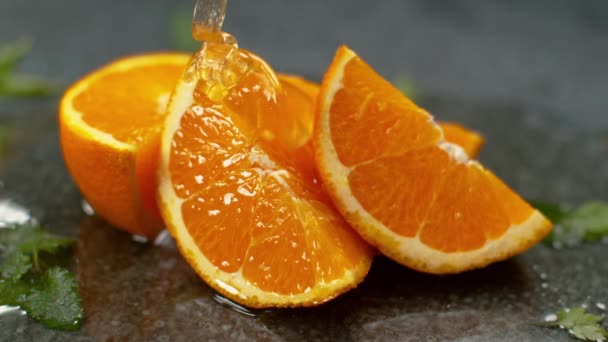 スローモーション、マクロ:おいしいゼリーはジューシーなオレンジのスライスに渦巻いています. - 映像、動画