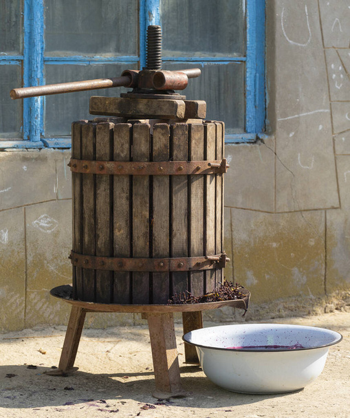 Elaboración. Tecnología de producción de vino en Moldavia. La antigua tradición popular del procesamiento de la uva. El exprimidor se utiliza para presionar el vino
.  - Foto, Imagen
