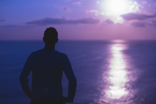 Férfi, szép trópusi nyári naplementével a szigeten az óceán felett. - Fotó, kép