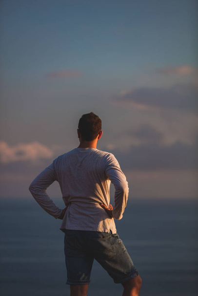 Человек с красивым тропическим летним закатом на острове над океаном
. - Фото, изображение