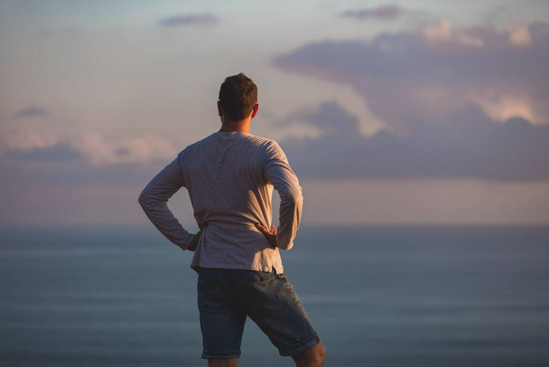 Людина з гарним тропічним літнім заходом сонця на острові над океаном
. - Фото, зображення